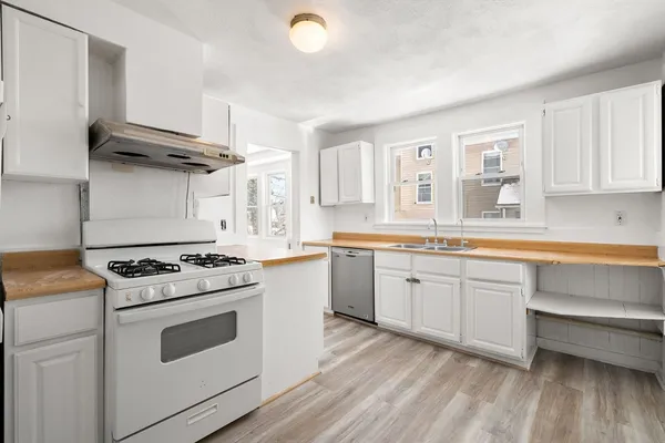 a kitchen with granite countertop white cabinets and white appliances