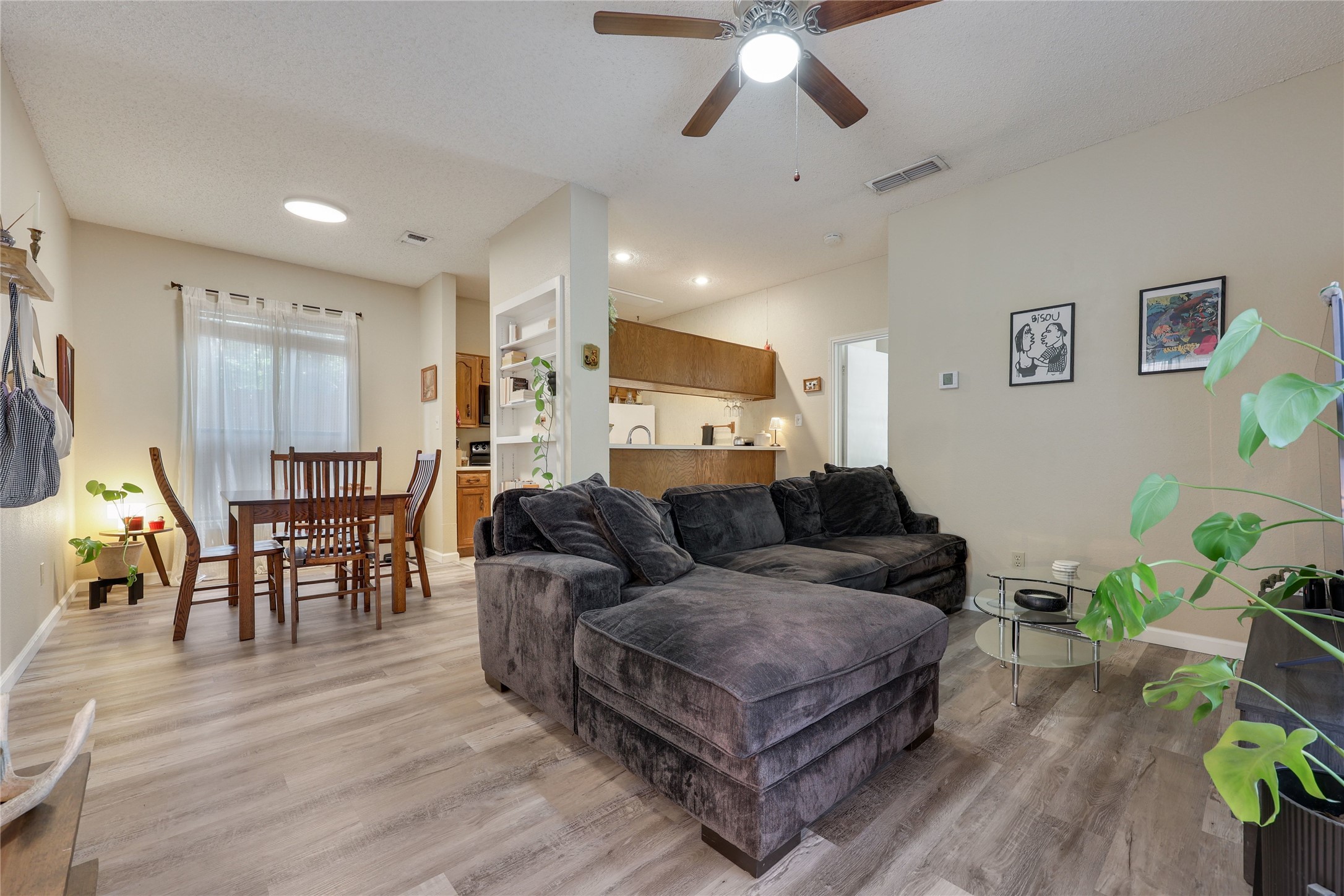 3011 Fruth Street, Unit 101 Austin, TX 78705 - Photo 3 of 14 An inviting open-concept space features warm wood flooring and a classic ceiling fan for comfort.