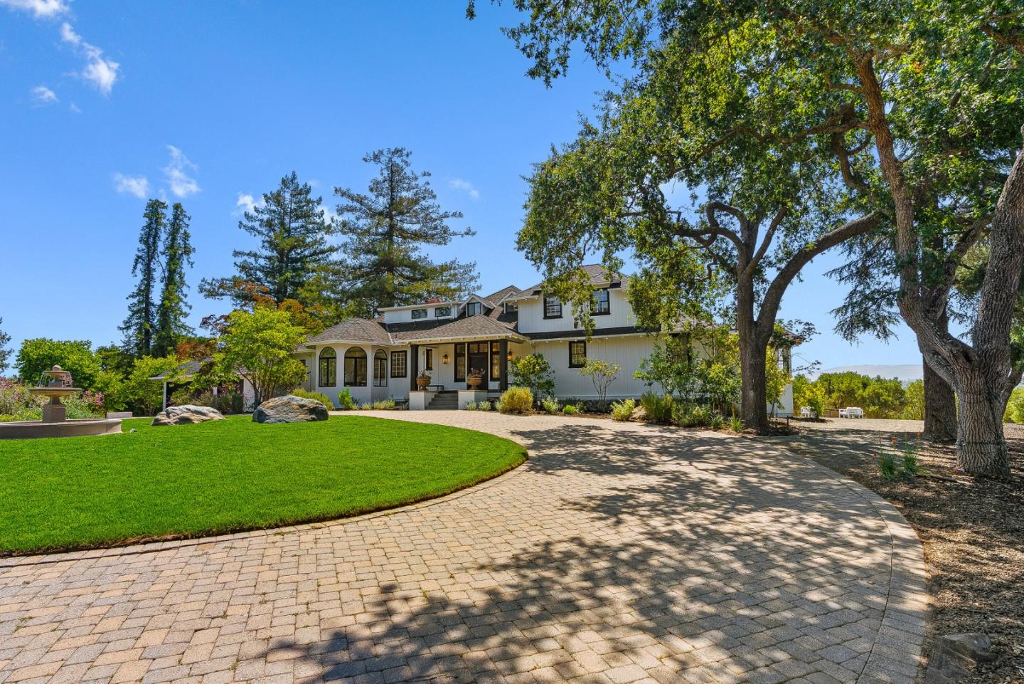 a front view of a house with a garden and tree