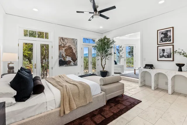 a bedroom with a large bed and a chandelier