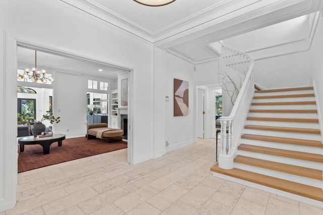 a living room with furniture a fireplace and a chandelier