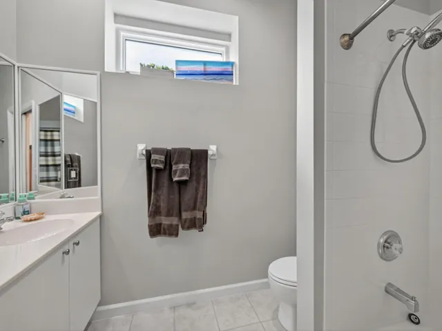 a bathroom with a granite countertop sink a toilet and shower