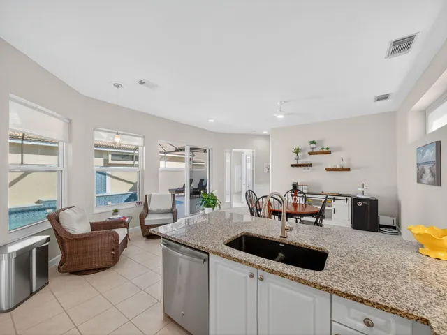 a kitchen with granite countertop a sink and white cabinets