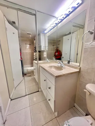 a bathroom with a sink a toilet a mirror and shower