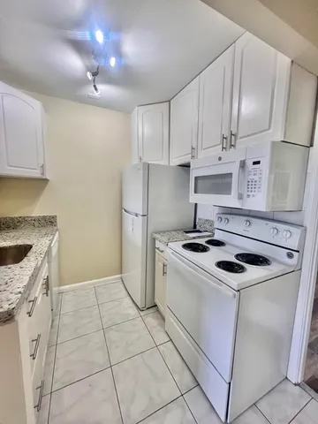 a kitchen with granite countertop a sink stove and refrigerator