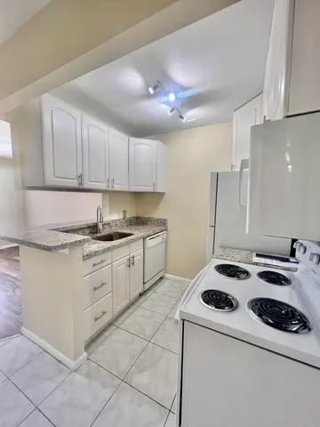 a kitchen with a stove sink and cabinets
