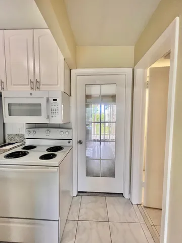a kitchen with white cabinets and appliances