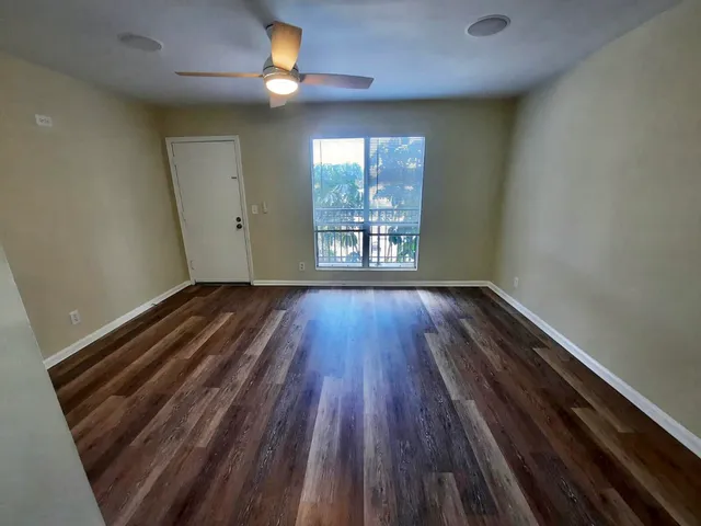 wooden floor in an empty room with a window