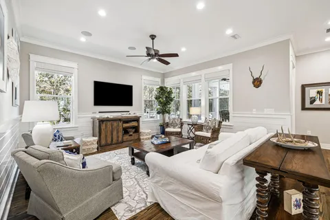 a living room with furniture a flat screen tv and a chandelier