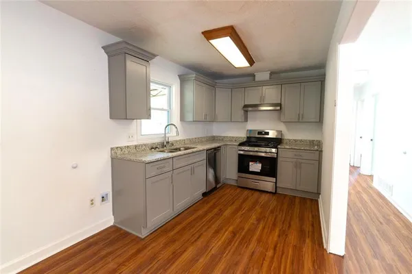 a kitchen with granite countertop a stove top oven and sink