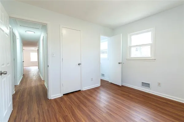 a view of a room with wooden floor and white walls