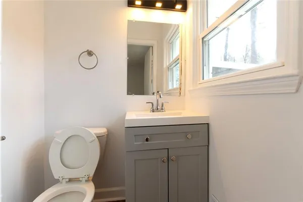 a bathroom with a toilet a sink and mirror