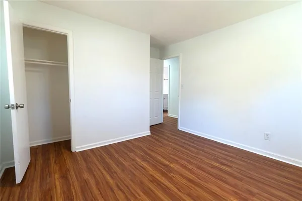 a view of an empty room with wooden floor