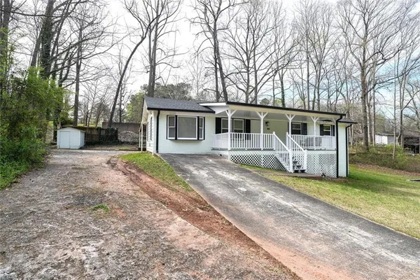 a front view of a house with yard and trees