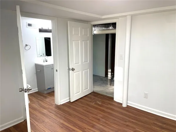 a view of a hallway with wooden floor and closet area