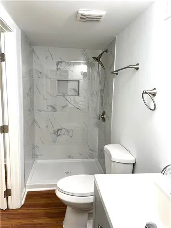 a bathroom with a toilet a sink and shower