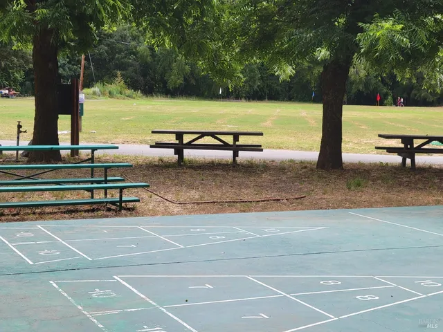 a view of a tennis court with lots of trees in the background