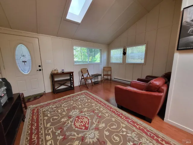 a living room with furniture a clock on wall and a window