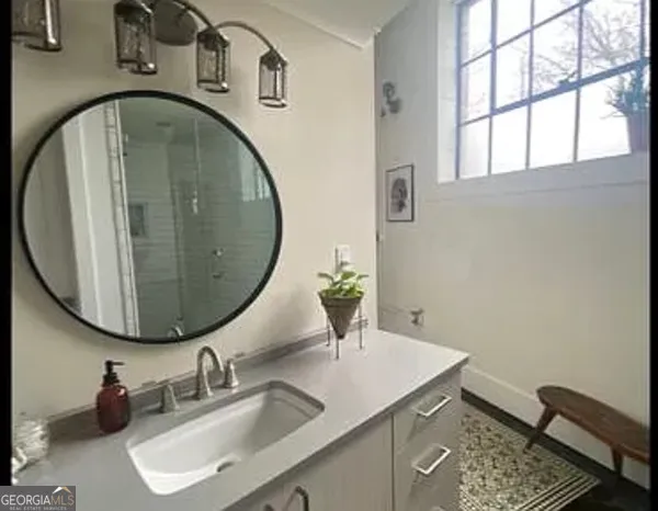 a bathroom with a granite countertop sink and a mirror