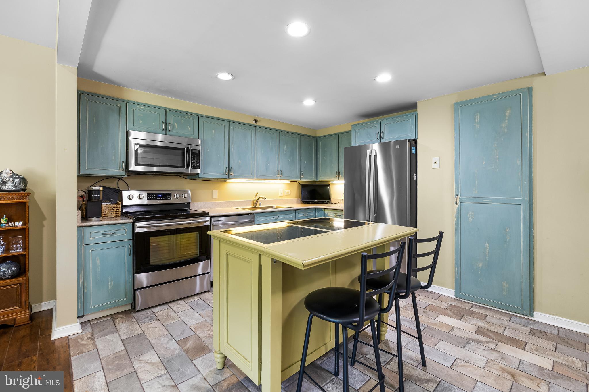 2331 Old Court Road, Unit 307 Baltimore, MD 21208 - Photo 16 of 54 a kitchen with kitchen island a refrigerator stove and microwave