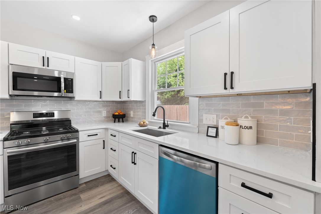 3139 Whitethorn Road Cleveland, OH 44118 - Photo 14 of 50 Kitchen with stainless steel appliances, light hardwood / wood-style floors, backsplash, and sink