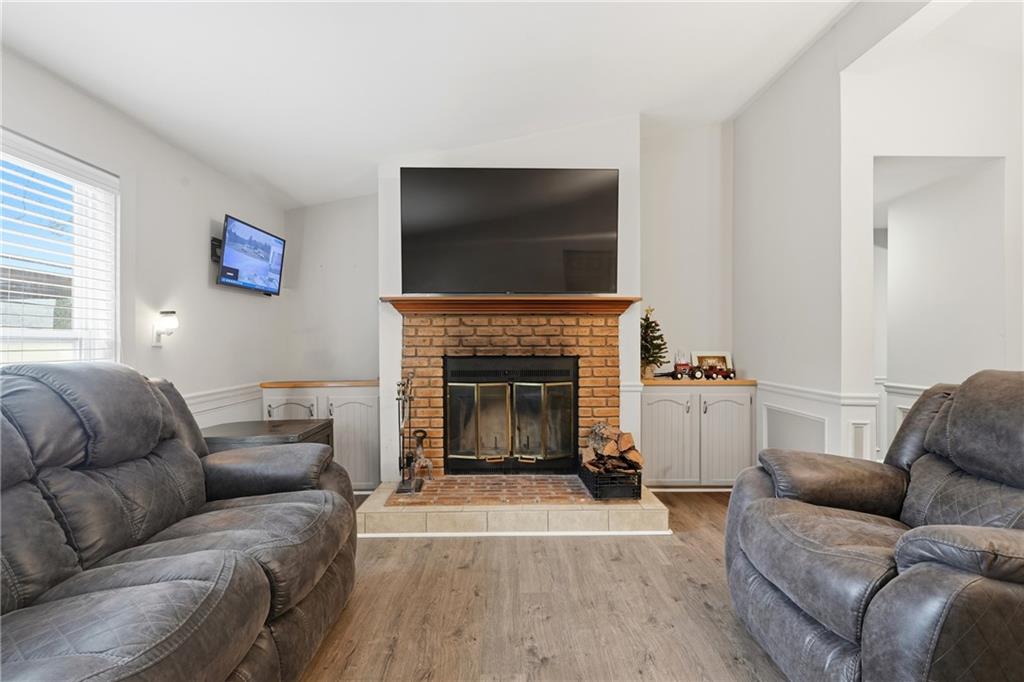 1295 Double Bridges Road Winder, GA 30680 - Photo 13 of 57 a living room with furniture a flat screen tv and a fireplace