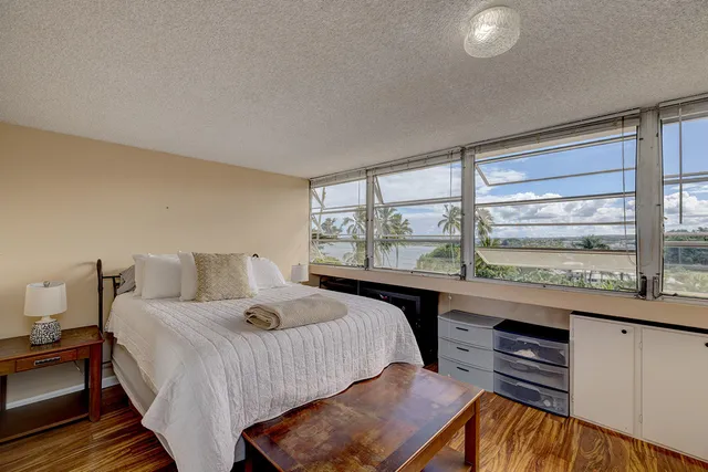 a bedroom with a bed and a large window with outer view