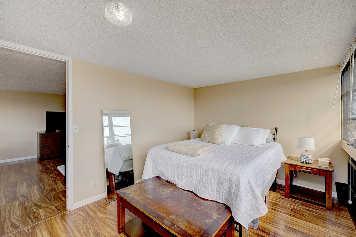 84 Pukihae Street, Unit 406 Hilo, HI 96720 - Photo 12 of 26 a bedroom with a bed and wooden floor