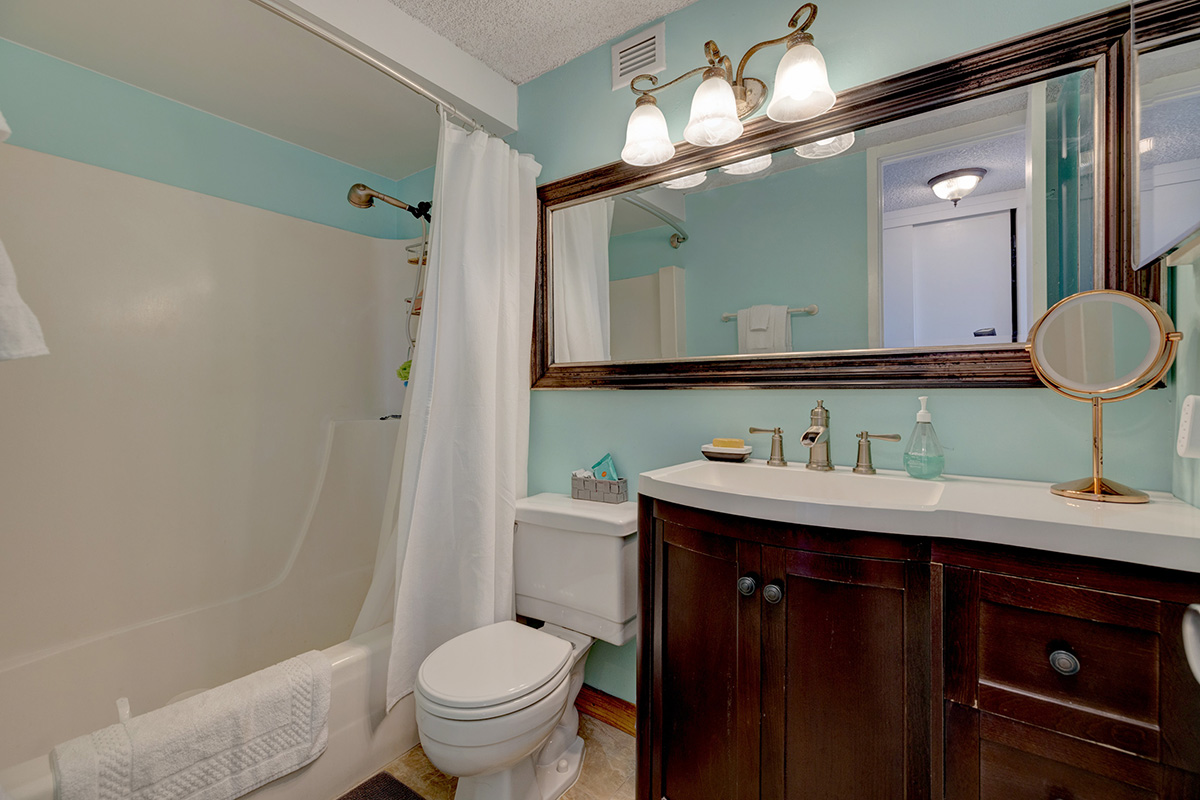 84 Pukihae Street, Unit 406 Hilo, HI 96720 - Photo 16 of 26 a bathroom with a granite countertop sink toilet a mirror a vanity and shower