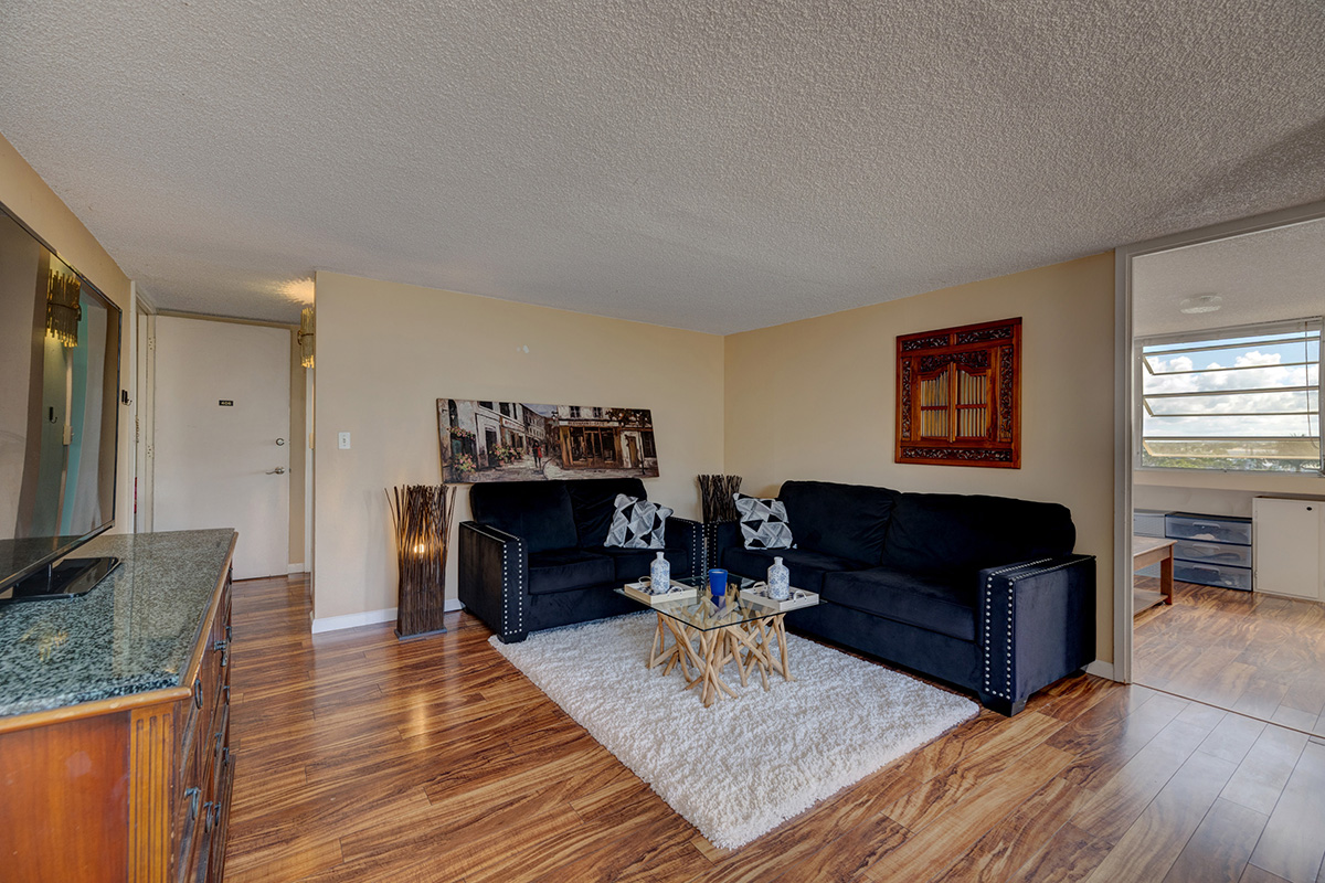 84 Pukihae Street, Unit 406 Hilo, HI 96720 - Photo 2 of 26 a living room with furniture and a wooden floor