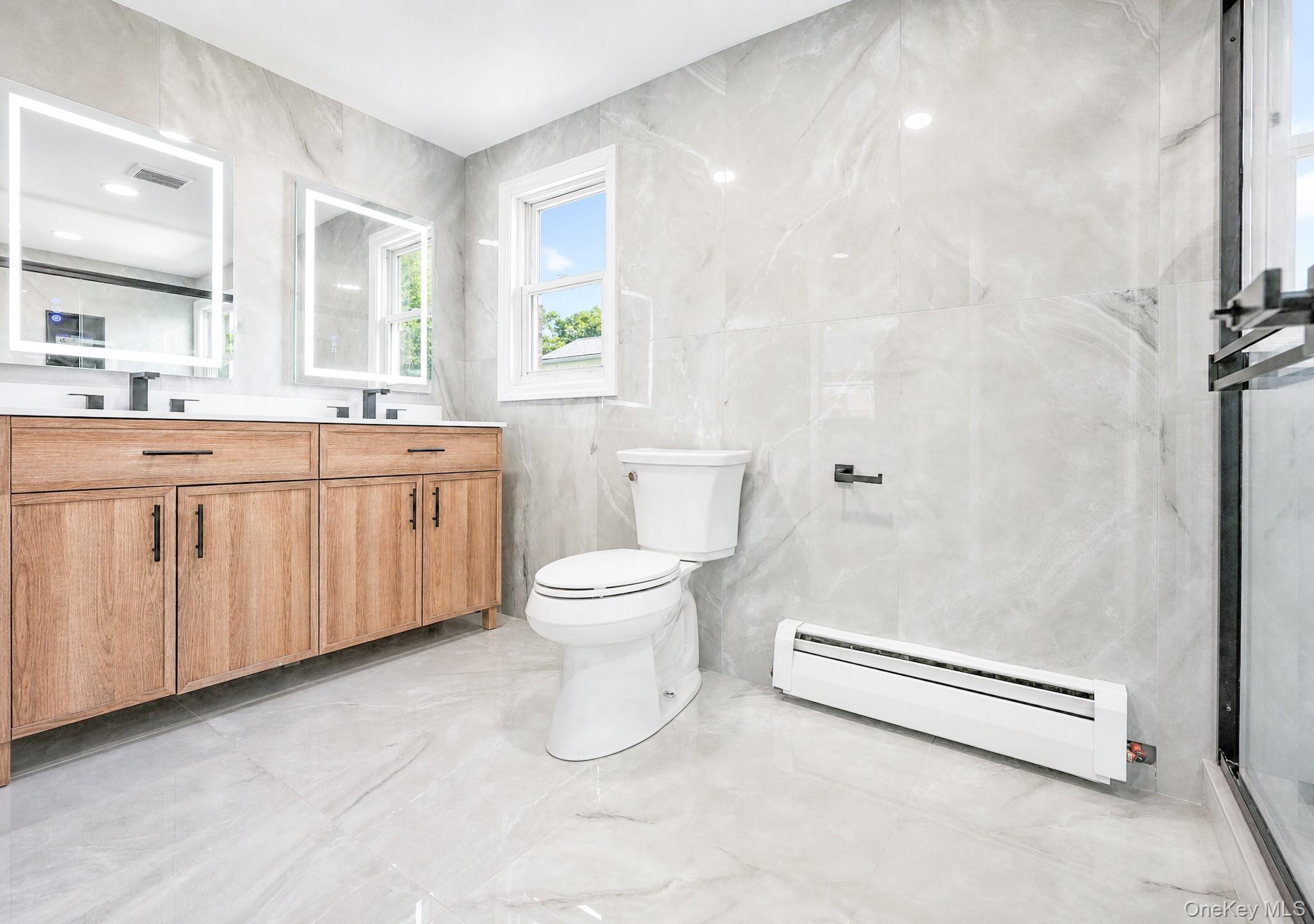 61 Cheshire Road Bethpage, NY 11714 - Photo 16 of 25 Bathroom featuring a double vanity with wood-finish cabinetry and rectangular illuminated mirrors
