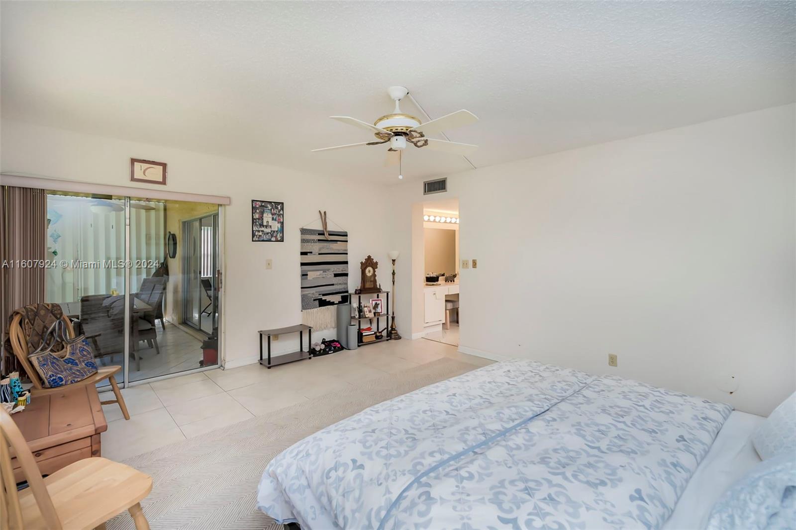 8780 Azalea Court, Unit 104 Tamarac, FL 33321 - Photo 11 of 37 a spacious bedroom with a bed and a chandelier
