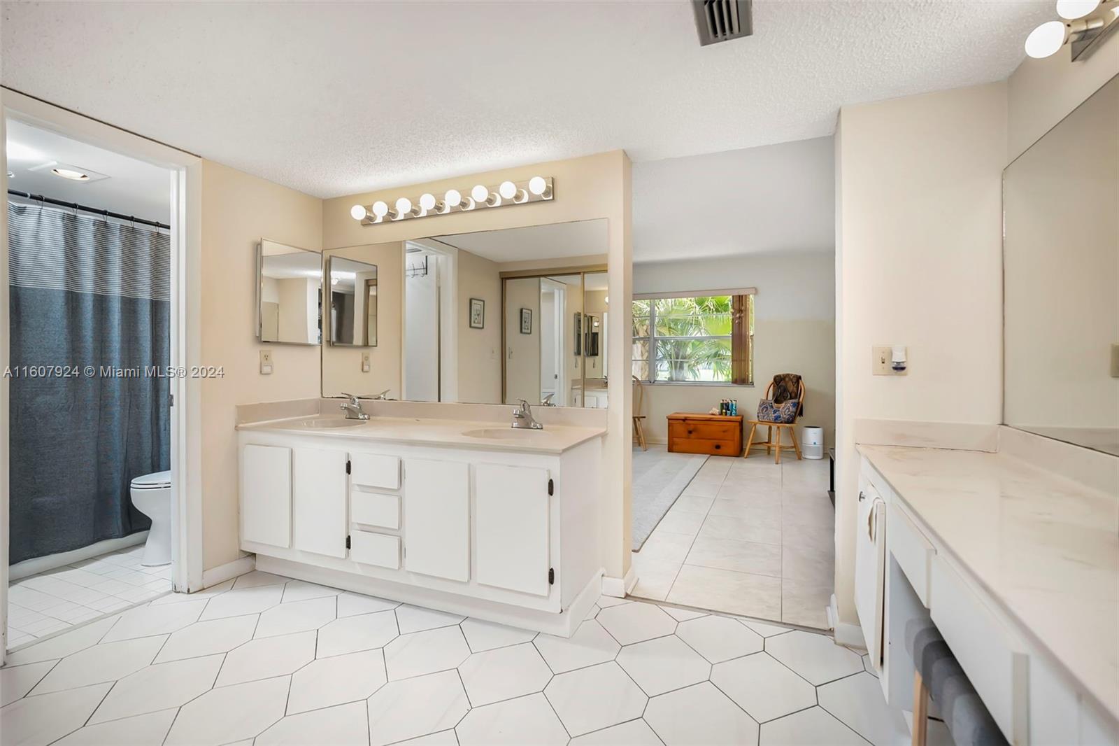 8780 Azalea Court, Unit 104 Tamarac, FL 33321 - Photo 13 of 37 a spacious bathroom with a granite countertop sink mirror and bathtub