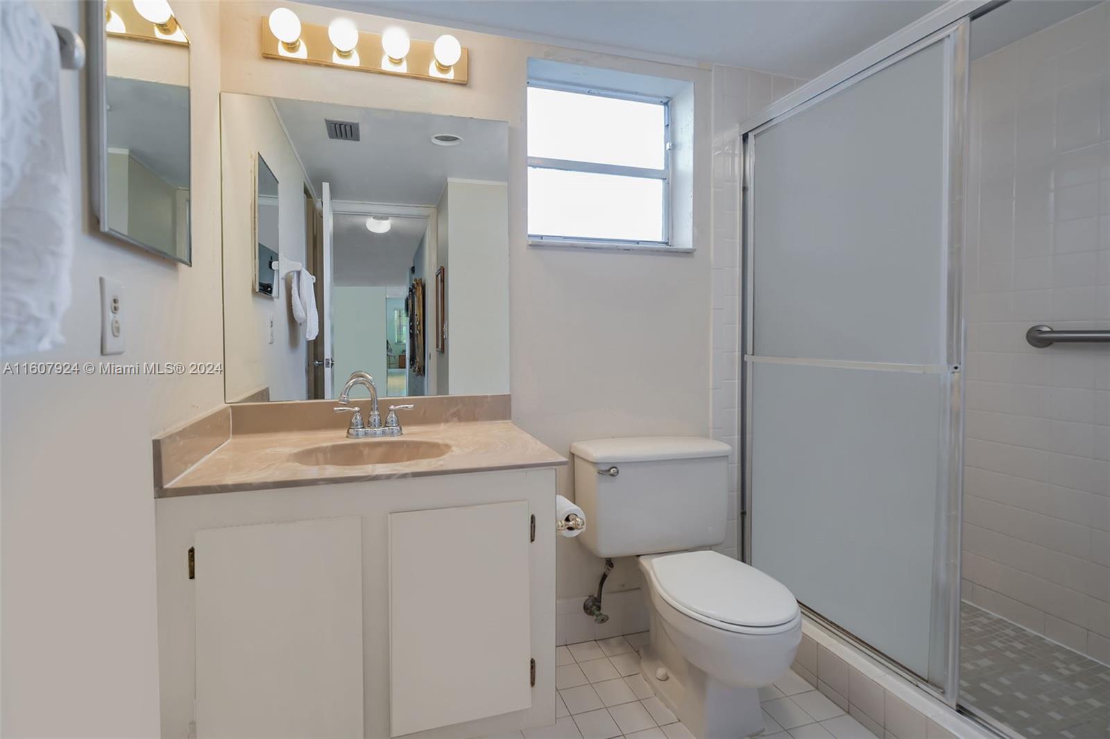 8780 Azalea Court, Unit 104 Tamarac, FL 33321 - Photo 14 of 37 a bathroom with a granite countertop toilet a sink and a mirror