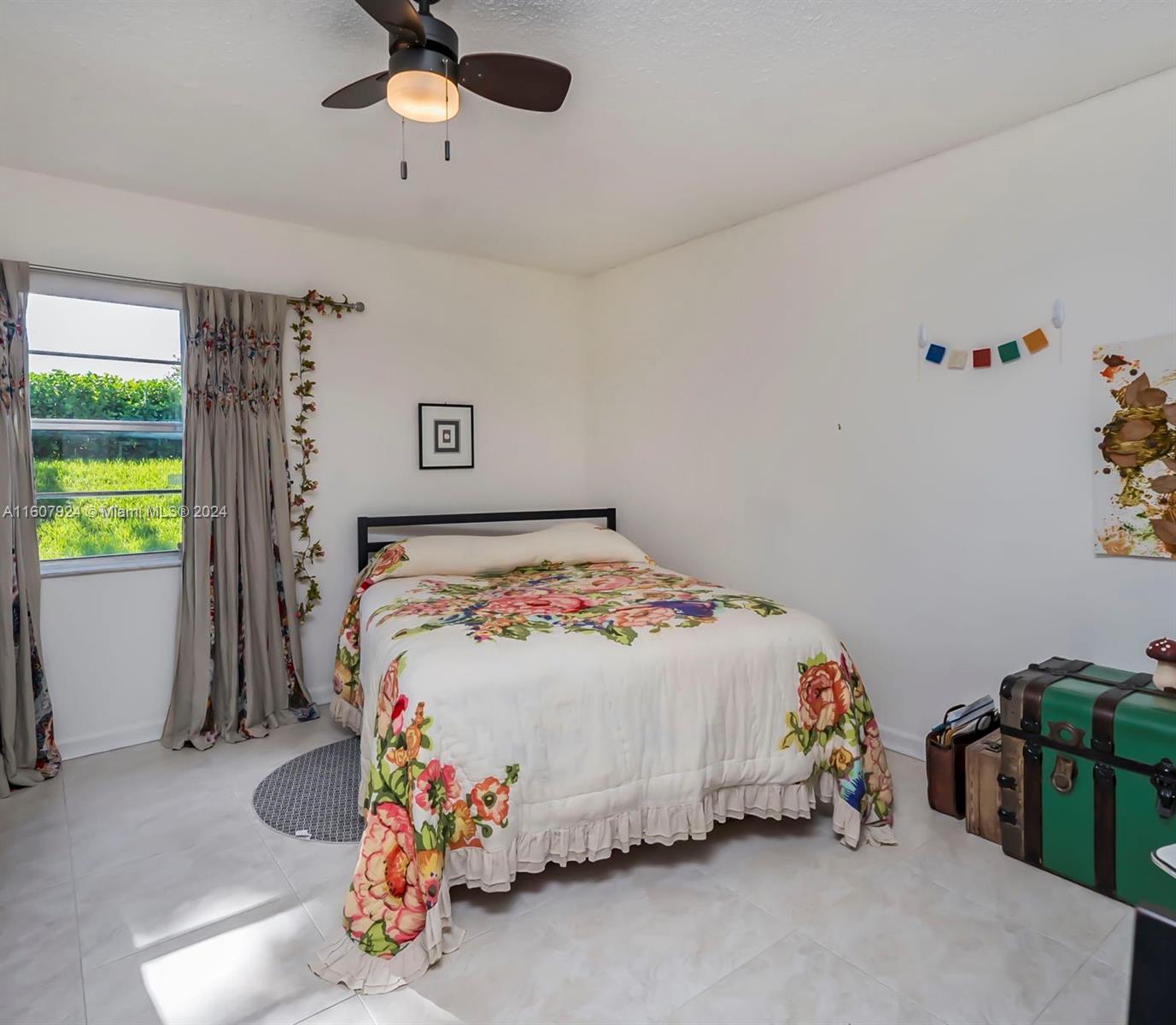8780 Azalea Court, Unit 104 Tamarac, FL 33321 - Photo 15 of 37 a bedroom with a bed and a chandelier