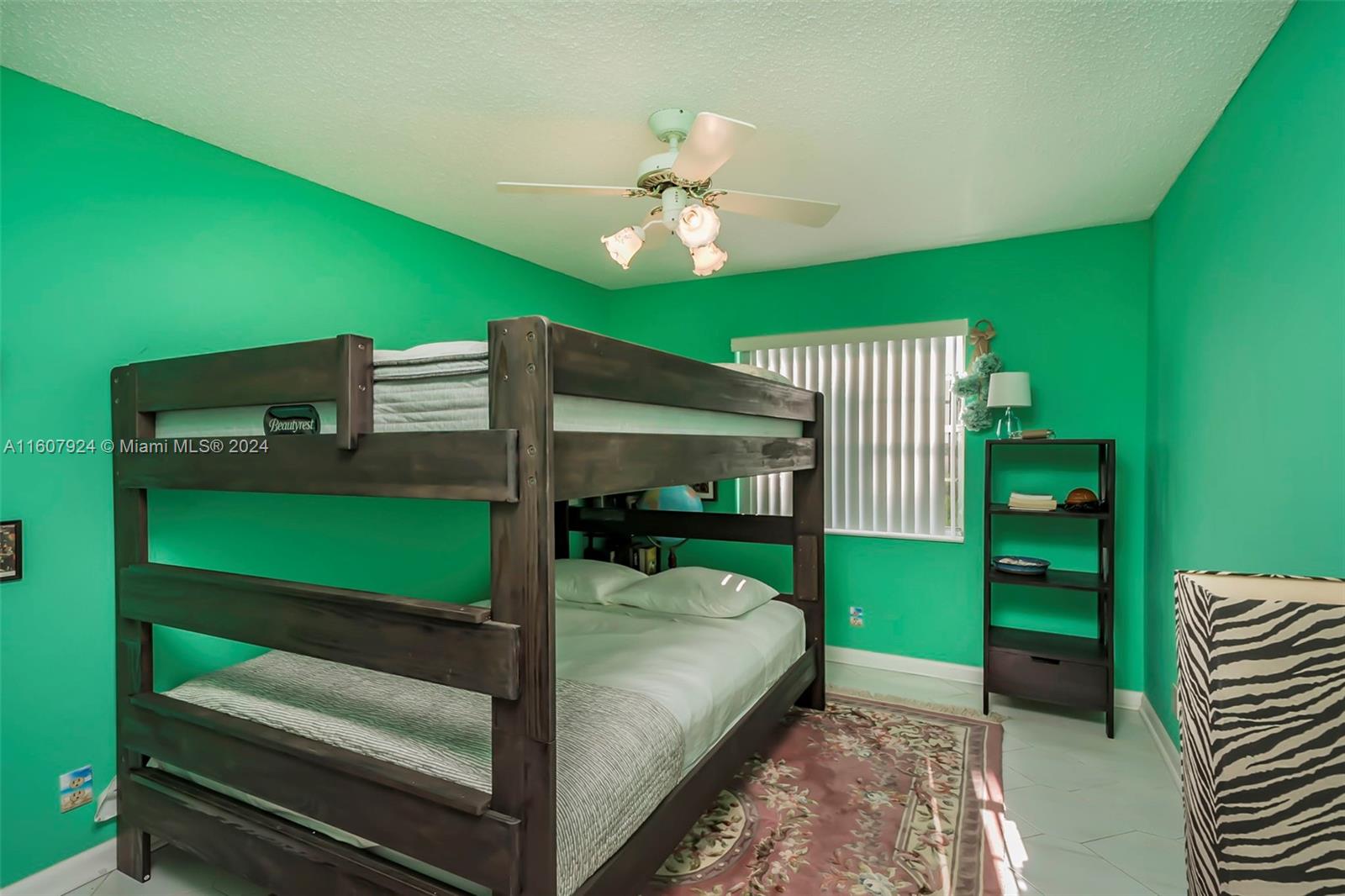 8780 Azalea Court, Unit 104 Tamarac, FL 33321 - Photo 16 of 37 a bedroom with a bed and a fan