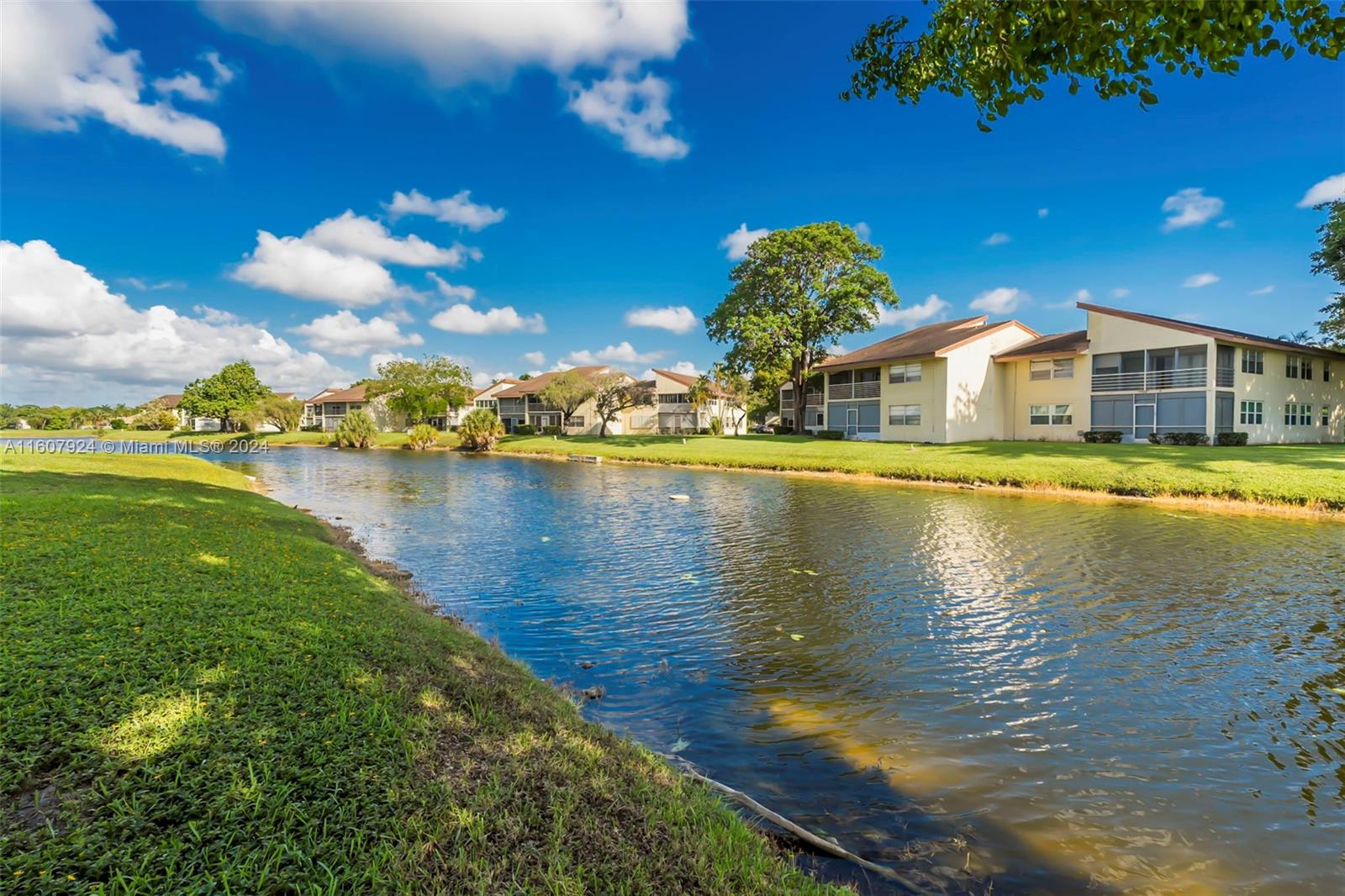 8780 Azalea Court, Unit 104 Tamarac, FL 33321 - Photo 2 of 37 a view of a house with a yard and swimming pool
