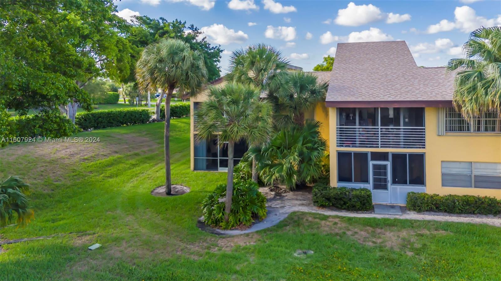 8780 Azalea Court, Unit 104 Tamarac, FL 33321 - Photo 29 of 37 a view of a house with a backyard and a patio