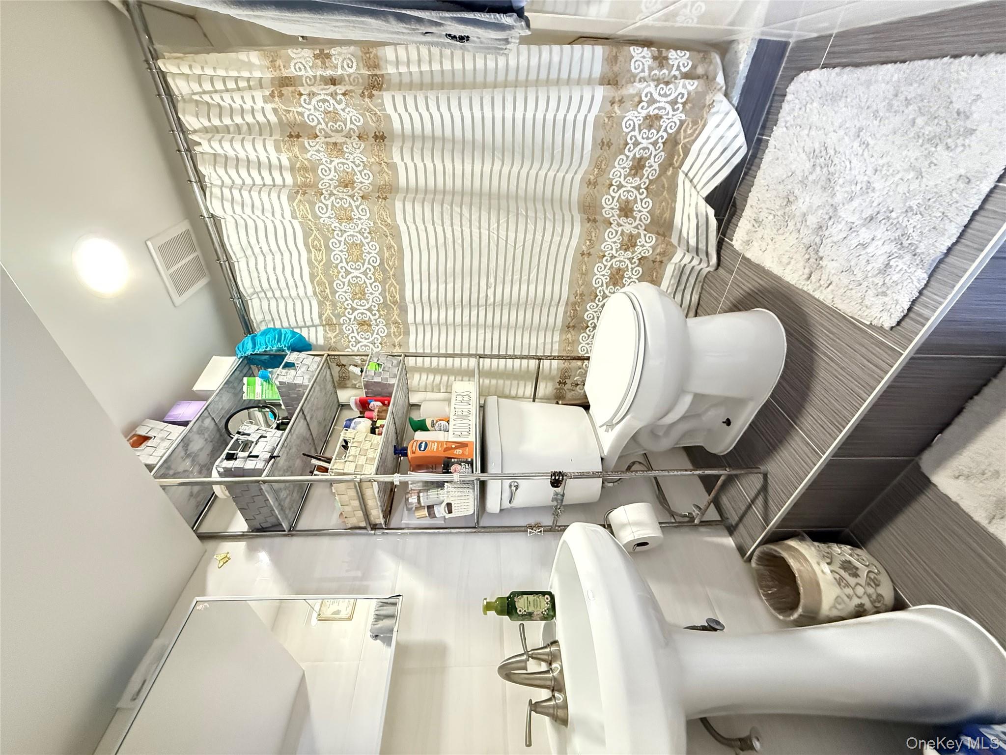 90-13 77th Street Queens, NY 11421 - Photo 13 of 16 a bathroom with a toilet sink and mirror