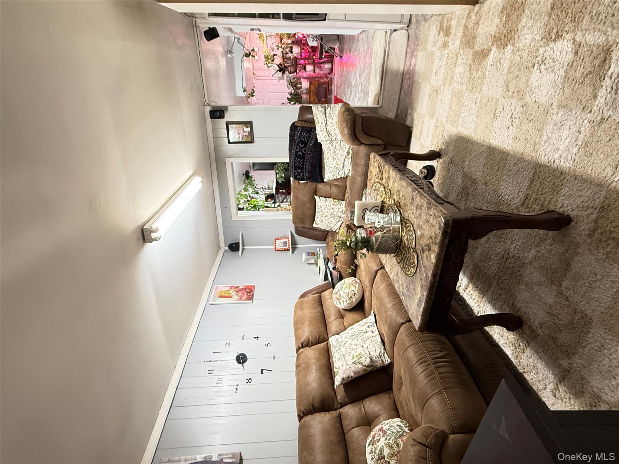 90-13 77th Street Queens, NY 11421 - Photo 16 of 16 a living room with furniture and a rug