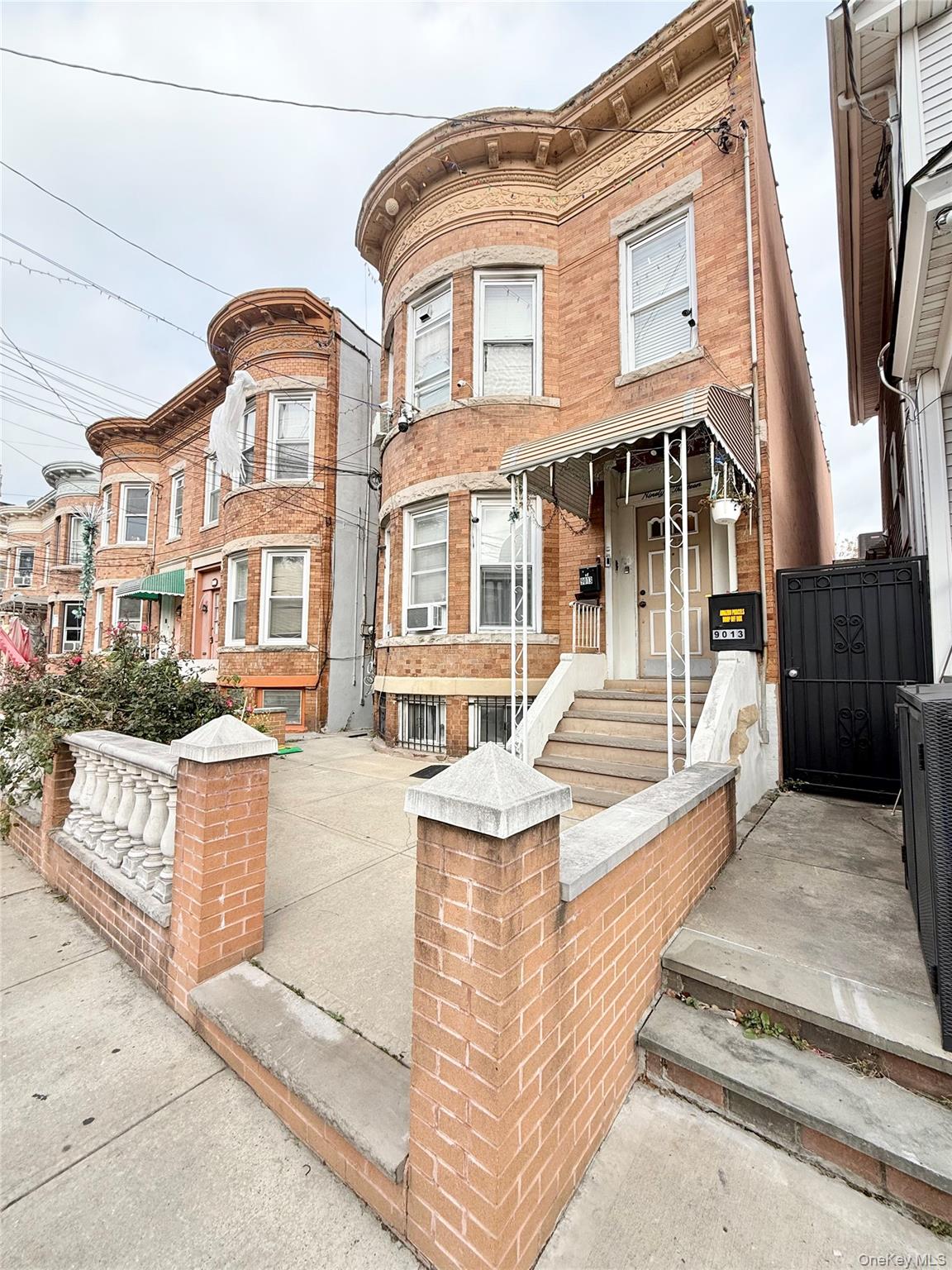 90-13 77th Street Queens, NY 11421 - Photo 3 of 16 a front view of a house with many windows