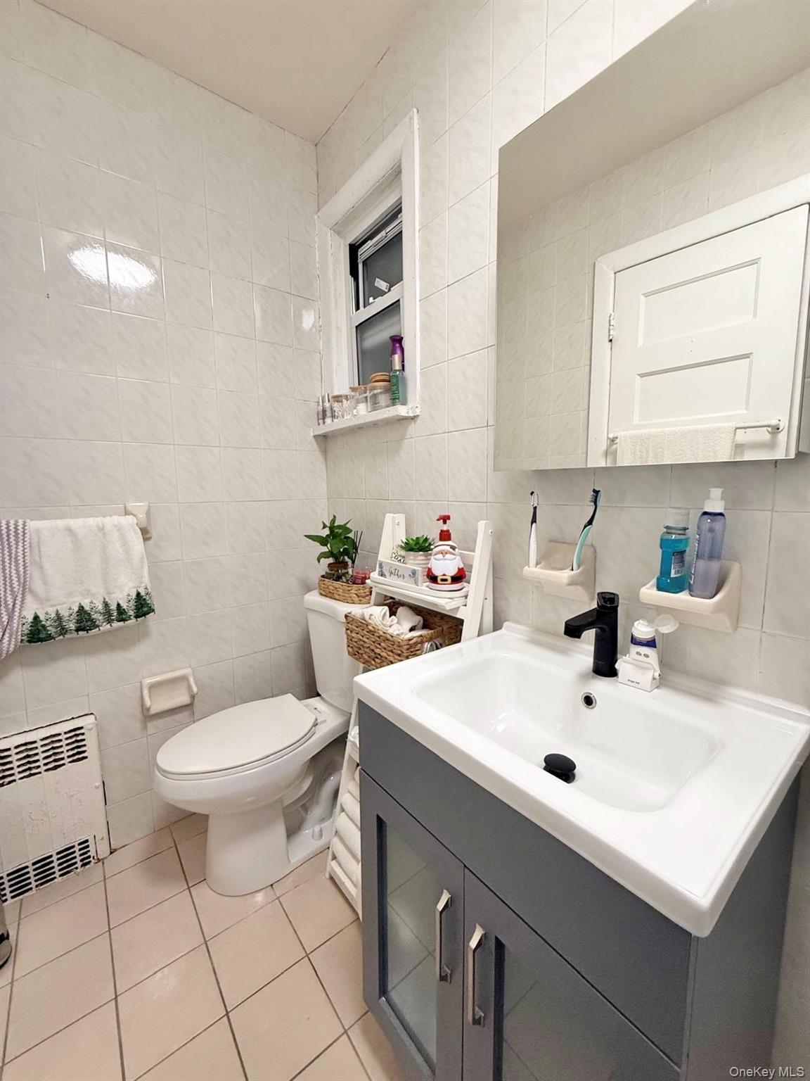 90-13 77th Street Queens, NY 11421 - Photo 9 of 16 a bathroom with a sink toilet and a window