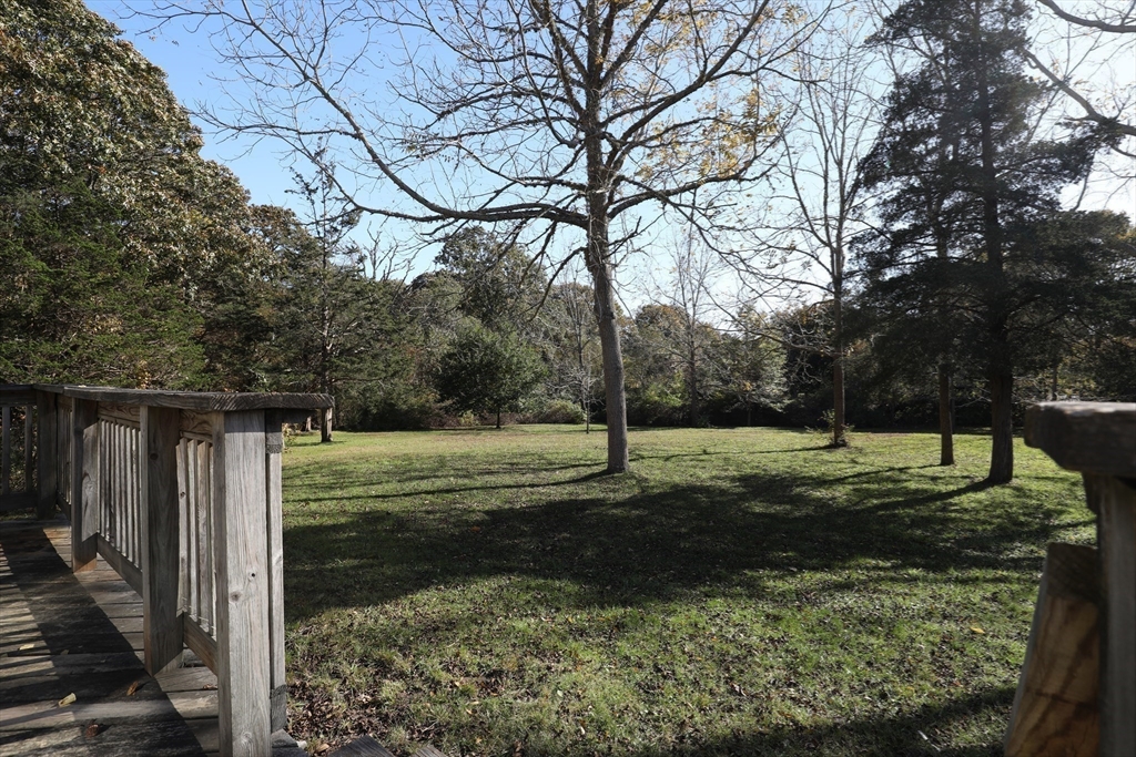 827 Shore Road Pocasset, MA 02559 - Photo 4 of 5 a backyard of a house with trees and outdoor seating