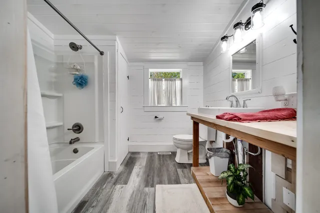 a kitchen with stainless steel appliances kitchen island granite countertop a table chairs sink and cabinets