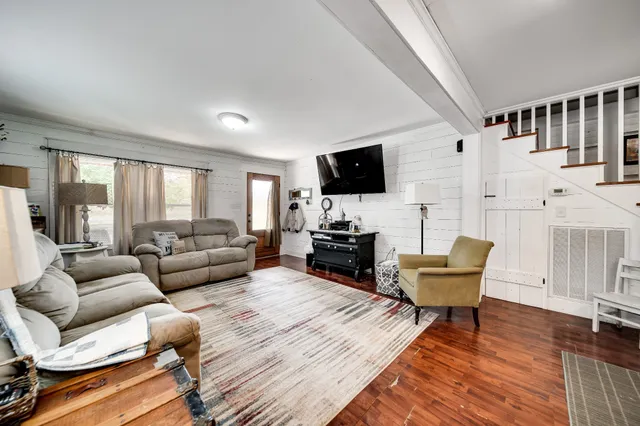 a kitchen with stainless steel appliances granite countertop a stove top oven a sink dishwasher and a refrigerator with wooden floor