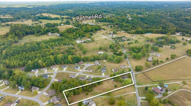 a view of a small house with roof and a yard