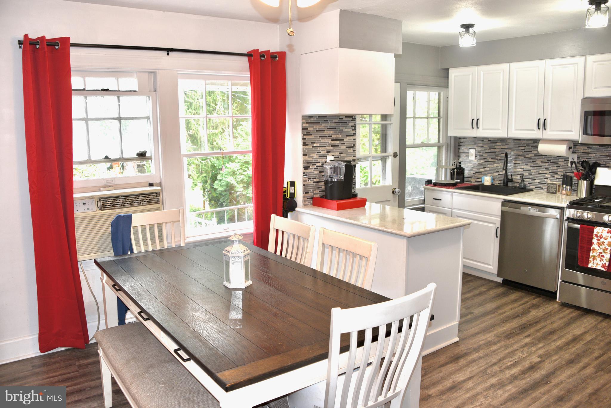 2545 Grant Street Reading, PA 19606 - Photo 6 of 25 a kitchen with stainless steel appliances granite countertop a stove a refrigerator a kitchen island a couches and chairs with wooden floor