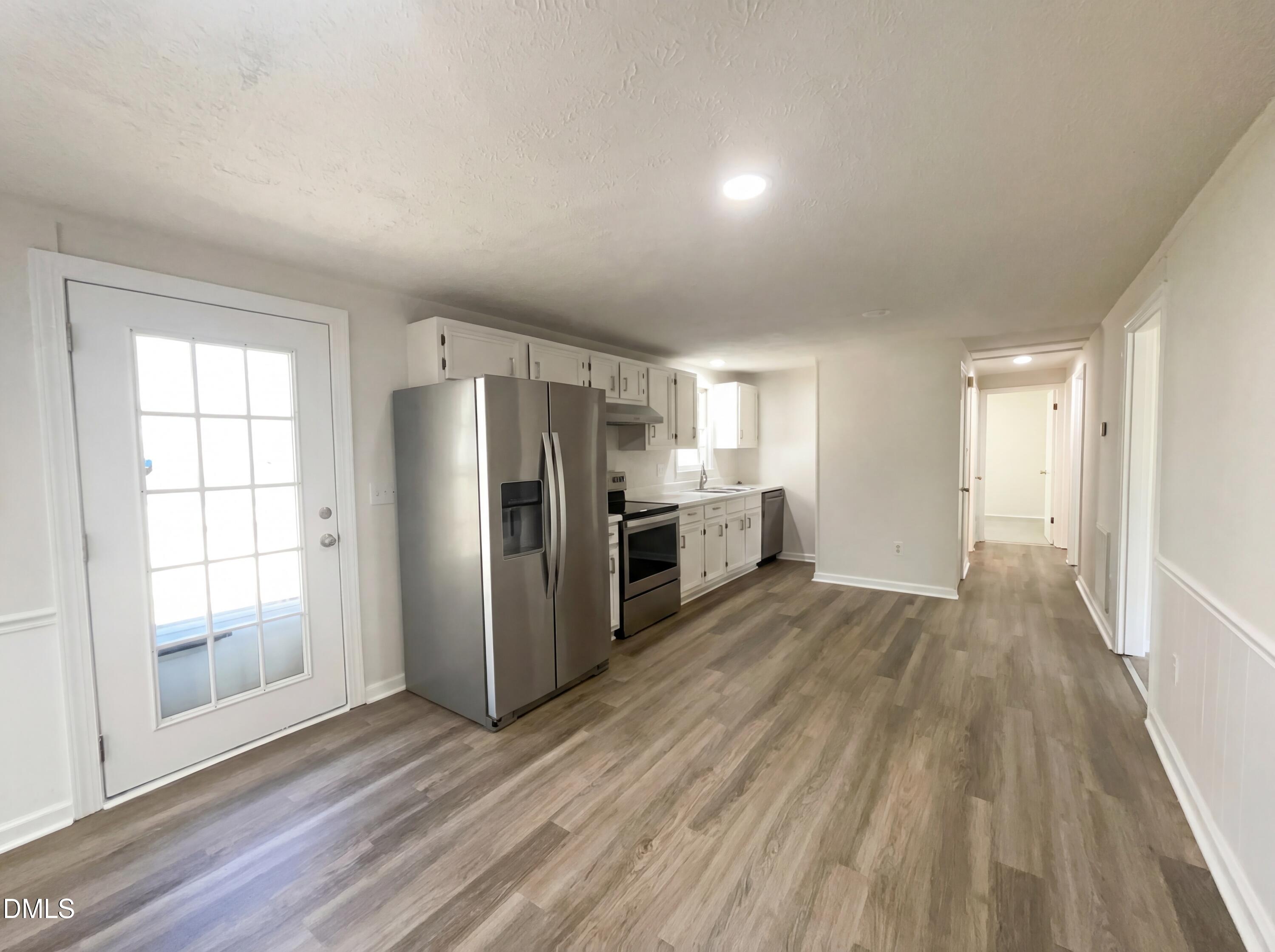 9815 Berry Road Timberlake, NC 27583 - Photo 6 of 17 an empty room with wooden floor kitchen view and windows
