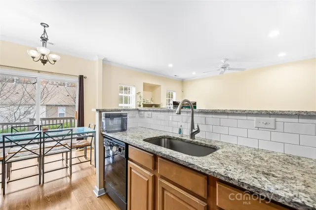a kitchen with stainless steel appliances granite countertop a sink stove microwave and refrigerator