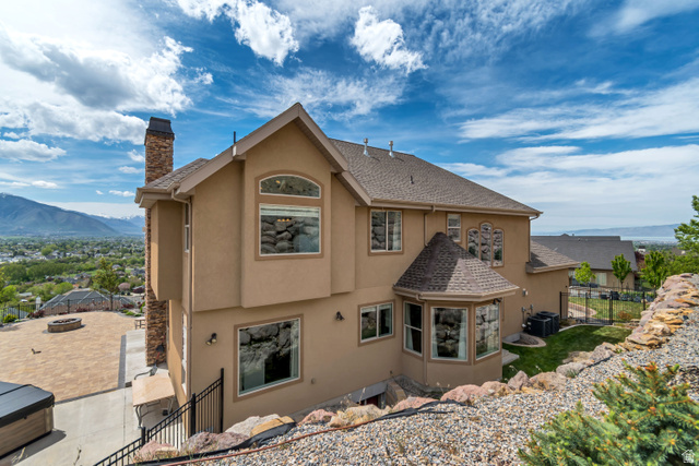 2543 East 700 South Springville, UT 84663 - Photo 11 of 73 Back of property with stucco siding, a chimney, a mountain view, and roof with shingles
